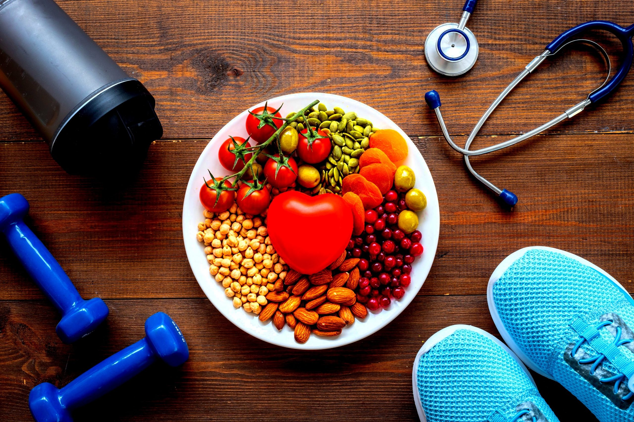 Domowe sposoby na to, jak obniżyć cholesterol: talerz ze zdrową żywnością, przyrządy do ćwiczeń i stetoskop